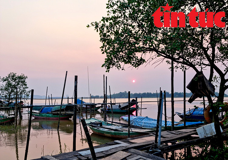 Làng chài nằm bình yên một góc sông dưới ráng chiều hồng tím ẩn hiện ở phía chân trời.