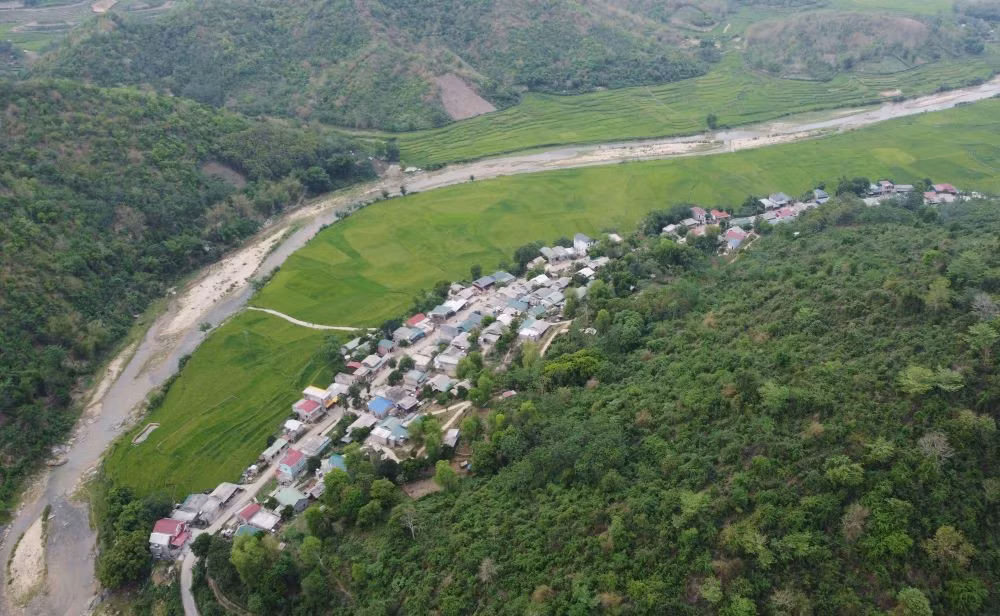 Những ngôi làng ở xã Quang Chiểu nằm nép mình bên sườn núi, hướng mắt ra dòng suối Sim hiền hòa, với hai bên bờ ruộng lúa xanh mát. Ảnh: Quách Du