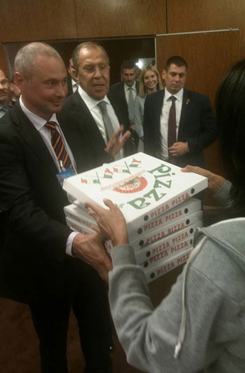 Đặc biệt, trong quá trình đàm phán, phái đoàn Mỹ ngỏ ý tạm hoãn để hội ý trong thời gian 9 tiếng. Khi quay trở lại, phía Mỹ đã mang theo những hộp bánh pizza để ngỏ lời xin lỗi do để đoàn Nga chờ đợi quá lâu. Ảnh: Ngoại trưởng Nga Sergei Lavrov mang 5 hộp bánh pizza ra đưa cho các phóng viên tác nghiệp bên ngoài phòng họp.