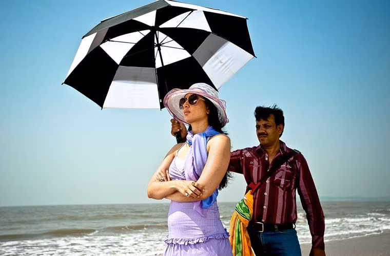 Trợ lý che ô cho nữ diễn viên Kareena Kapoor khi cô đi quay quảng cáo trên đảo Madh.