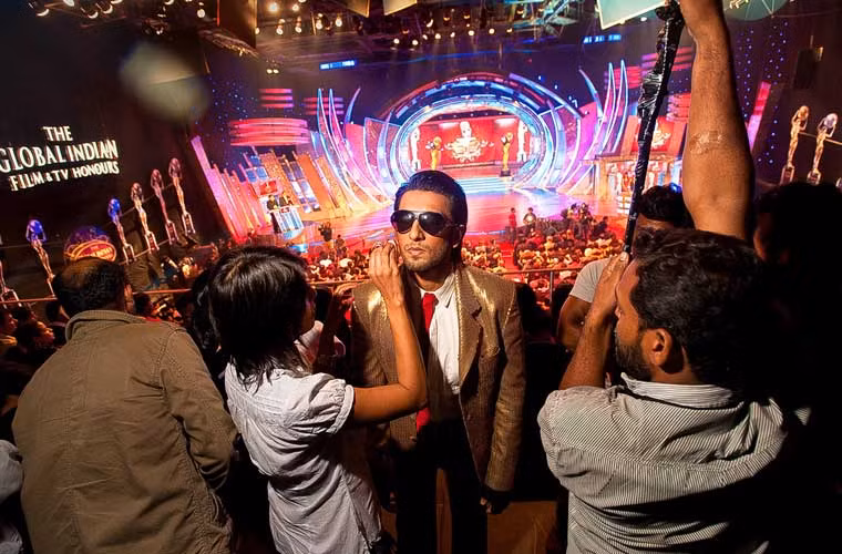 Cuộc sống hậu trường của các ngôi sao Bollywood được mô tả chân thực qua bộ sách ảnh Living the Dream: The Life of the "Bollywood" Actor của nhiếp ảnh gia Mark Bennington. Ảnh: Chuyên gia trang điểm đánh phấn lại cho nam tài tử Bollywood Ranveer Singh trước khi anh lên sân khấu.