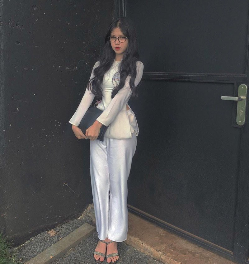 Có lần, hot girl còn gây chú ý khi biến tấu chiếc áo dài nữ sinh thành áo bà ba bằng cách vuốt thẳng 2 tà áo dài và xếp gọn thành tà ngắn qua hông, khéo léo nhét phần còn thừa vào quần.