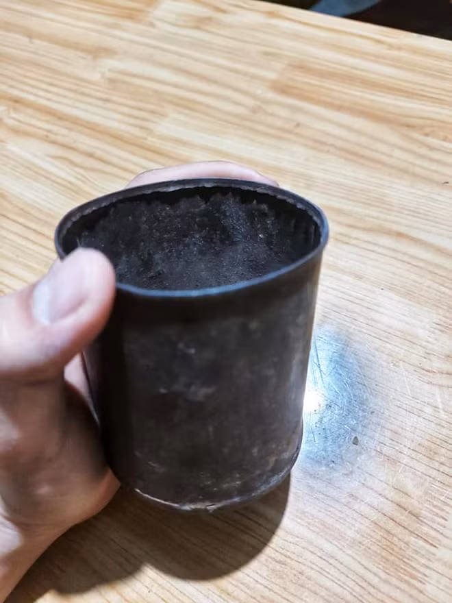 Có thể thấy, chiếc lon đong gạo cũ kỹ này đã nhuốm màu đen nhẻm, thậm chí còn bị thủng một lỗ ở dưới đáy lon.