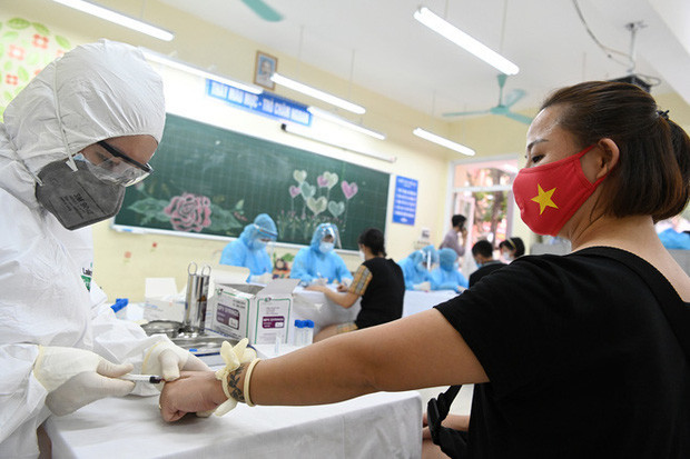 Những ngày vừa qua, nhiều nơi trên địa bàn Hà Nội đã tiến hành lấy mẫu xét nghiệm với các trường hợp người dân về từ Đà Nẵng. Người dân đã chấp hành đúng quy định như tự giác đeo khẩu trang, hoặc mặc đồ bảo hộ kín mít khi đến các cơ sở xét nghiệm nhanh COVID-19. Ảnh: Nam Khánh