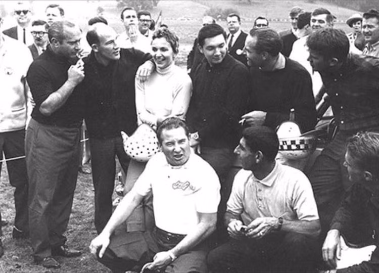 Denise McCluggage (20/1/1927 – 6/5/2015): Ở bức ảnh này, Denise McCluggage đang đứng cạnh những tay đua ôtô vĩ đại Stirling Moss và Juan Manuel Fangio. Bà không chỉ là một nhà báo tài ba mà còn có một tay đua ôtô nữ thành công, nhiều lần giành chức vô địch ở giải Nassau Ladies Race và tại giải Monte Carlo Rally 1964.