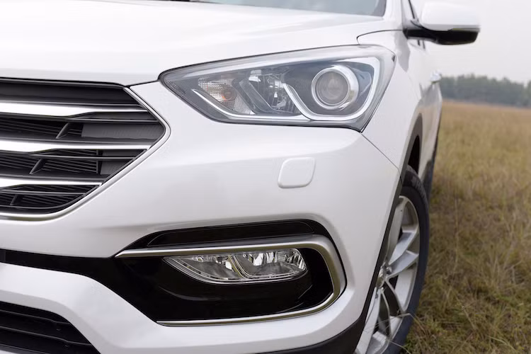 Ở phần đầu, SantaFe 2016 có đèn pha xenon projector dạng tròn cùng lưới tản nhiệt hình lục giác đặc trưng mạ chrome được thiết kế lại, khiến chiếc xe mang hình dáng hiện đại hơn.