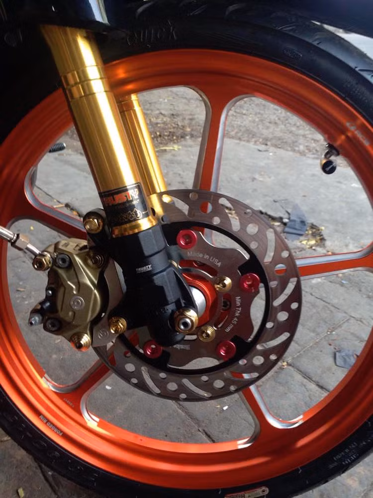 Ở phía trước, chiếc xe được gắn vỏ phuộc Trusty, đĩa kiểng và heo Brembo 2 pis kèm pát CNC. Tuy nhiên, điểm nổi bật nhất phải kể tới bộ mâm nhôm CNC Racing Boy.