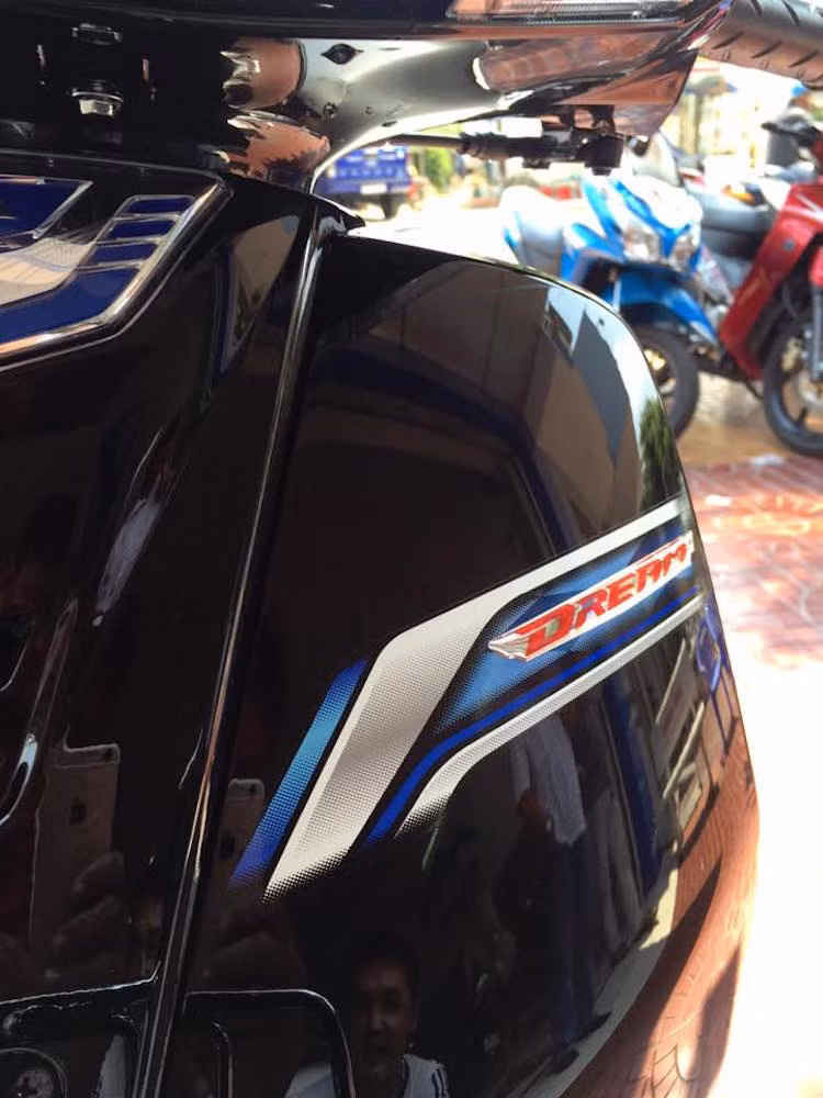 Thay vì logo bằng nhựa mạ chrome như Dream Thái hay tem giấy như Super Dream Việt Nam, tem yếm của Dream 125 2016 có chữ Dream dạng tem mềm trên nền tem giấy. Một điểm đặc biệt của chiếc xe đó là yếm sơn cùng màu thân, thay vì yếm trắng như trước đây.