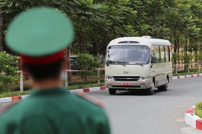Nếu xong các bước trên mà phát hiện ai có triệu chứng của COVID-19 như sốt, ho, khó thở thì được đưa qua bàn riêng để kiểm tra y tế. Sau đó đưa vào khu vực cách ly. Sau khi sát khuẩn, chiếc xe đưa các công dân vào khu vực kiểm tra tiếp theo. Ảnh: HOÀNG GIANG