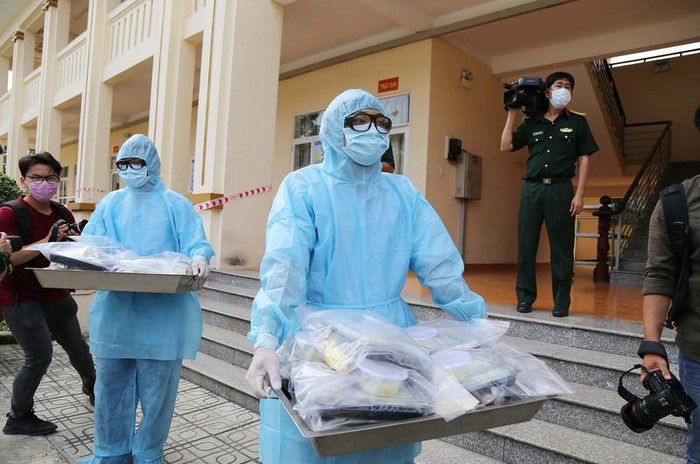 Nhân viên y tế mặc đồ bảo hộ khi tiếp xúc với công dân tại khu cách ly. Ảnh: HOÀNG GIANG