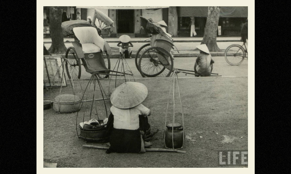 Người bán hàng rong và phu kéo xe trên đường phố Huế. (Nguồn: Life)