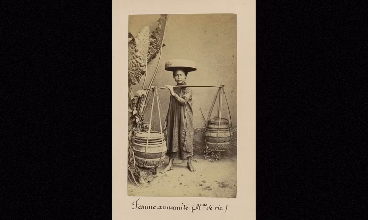 Bé gái Việt Nam với cặp quang gánh trên vai. (Nguồn: Émile Gsell)