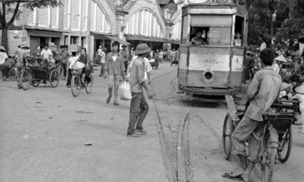 Đường tàu điện (phía trước chợ Đồng Xuân), phương tiện công cộng rất quan trọng ở Hà Nội thập kỷ 1970 – 1980... Tiếng leng keng của tàu điện là một kí ức đẹp trong lòng người Hà Nội. Nhảy tàu cũng là một "thú vui" của thanh niên thời bấy giờ. (Nguồn: Tiền Phong)