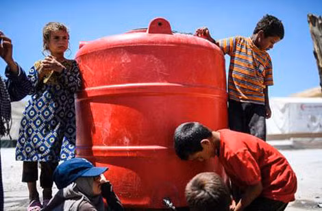 Trẻ em giành nhau lấy nước ở trại tị nạn Ain Issa.