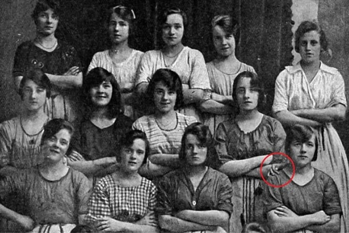 Kỳ lạ là người phụ nữ đứng ngay sau cô gái trên cũng đứng trong tư thế khoanh tay và bên phải cô không hề có ai đứng cạnh. Theo đó, bàn tay đặt trên vai của cô gái ở hàng thứ ba đứng ngoài cùng không thuộc về bất cứ người phụ nào.