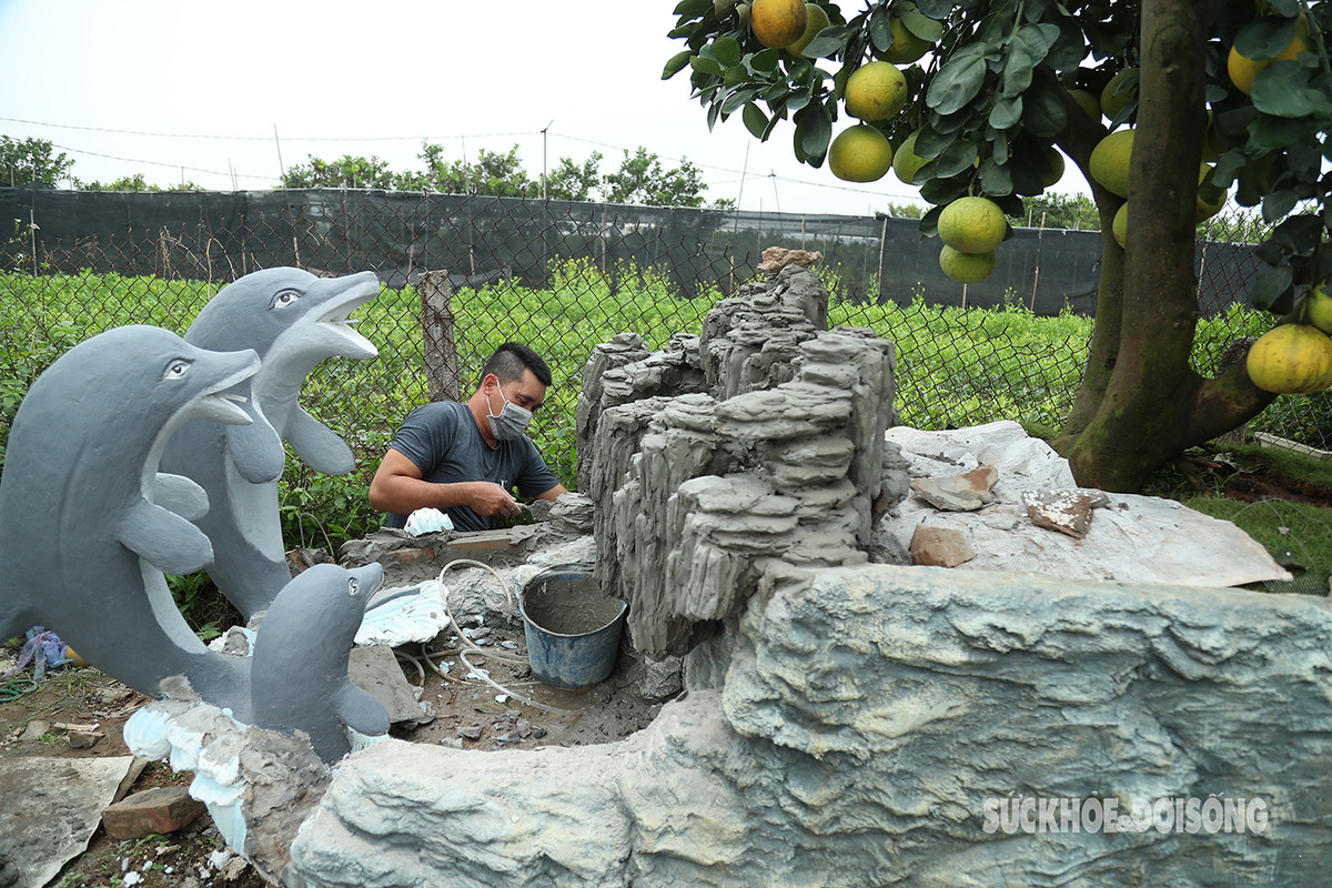 Người thợ đang hoàn thiện tác phẩm "Đất liền và biển cả". "Để hoàn thành các tác phẩm này, những người thợ phải làm rất tỉ mỉ, thậm chí không ưng ý phải đập đi làm lại rất mất công. Vì vậy giá thành của những tác phẩm này không hề rẻ, anh Đức nói.