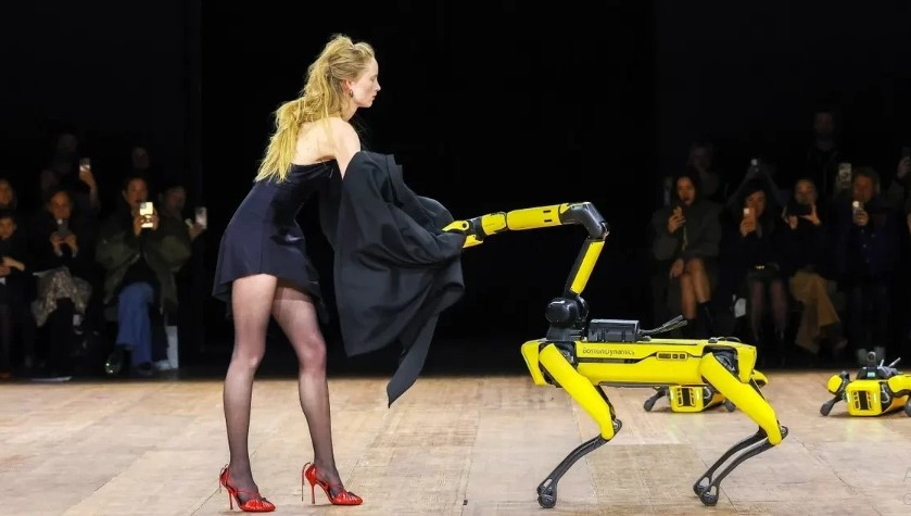 Không xé quần áo tơi tả như Avavav, thương hiệu Coperni để robot cởi đồ của người mẫu trong show diễn tổ chức tại Paris, Pháp. Rianne Van Rompaey là người mẫu phụ trách tiết mục độc lạ này. Khi đang trình diễn, cô gặp sự cố trang phục nhưng sau đó nhanh chóng sửa sang và sải bước một cách tự tin. Nhà thiết kế đứng sau bộ sưu tập muốn gửi gắm thông điệp rằng con người và công nghệ có thể "chung sống hòa thuận". Ảnh: Vogue.