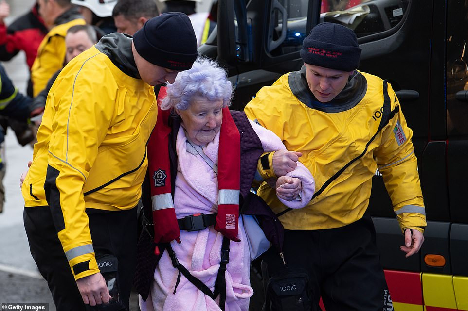 Một cụ bà được đưa ra khỏi ngôi nhà bị ngập lụt ở Nantgarw, Wales, ngày 16/2.