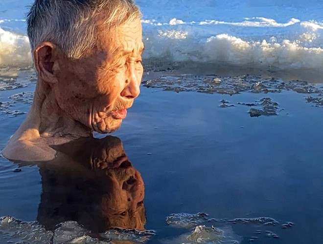 Bất chấp nước lạnh, một cụ già tắm trong hố băng ở làng Churapcha, Yakutia.