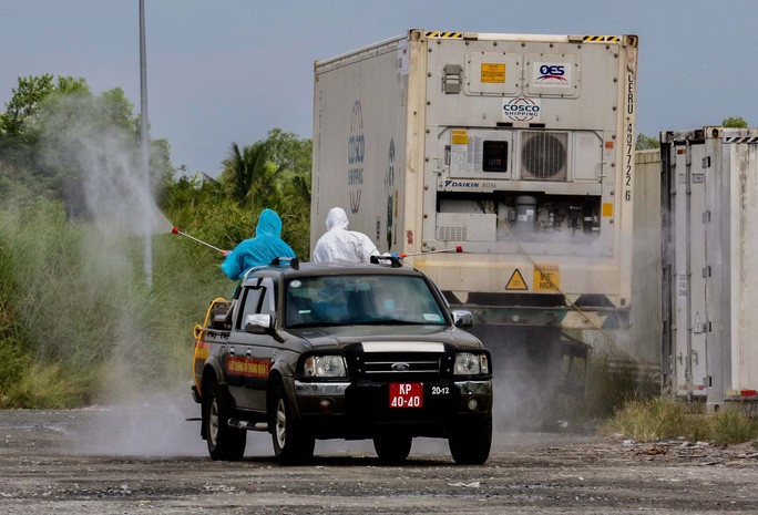 Ở những khu vực nhỏ khó vào, có xe chuyên dụng và 2 người đứng 2 bên hông xe để phun thuốc khử khuẩn.