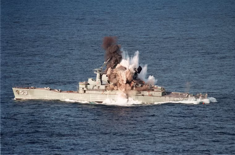 Chiếc tàu khu trục HMAS Torrens bị rung lên bần bật, phần đuôi như bị chìm hẳn xuống mặt nước, khói – nước – bụi bốc cao.