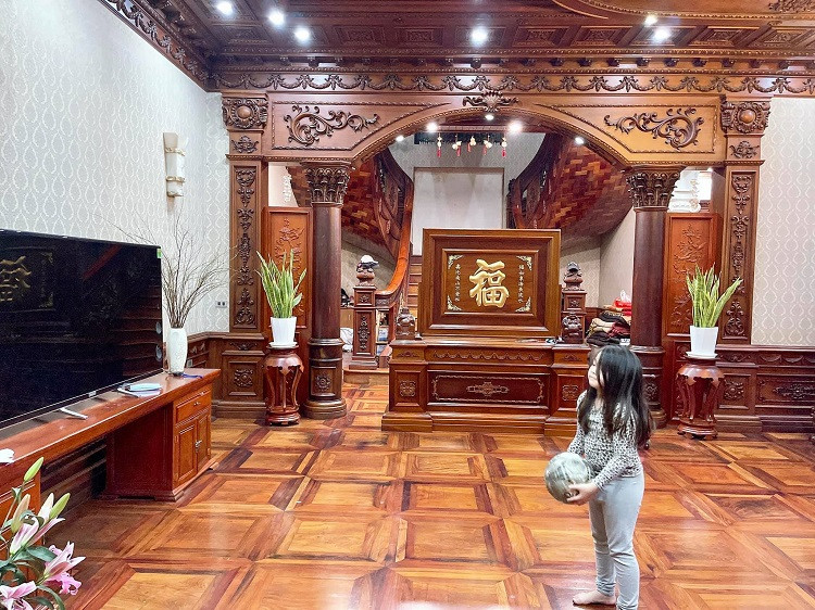 Phòng khách rộng rãi với sàn và trần được ốp gỗ gõ đỏ. Ảnh: Dân Việt