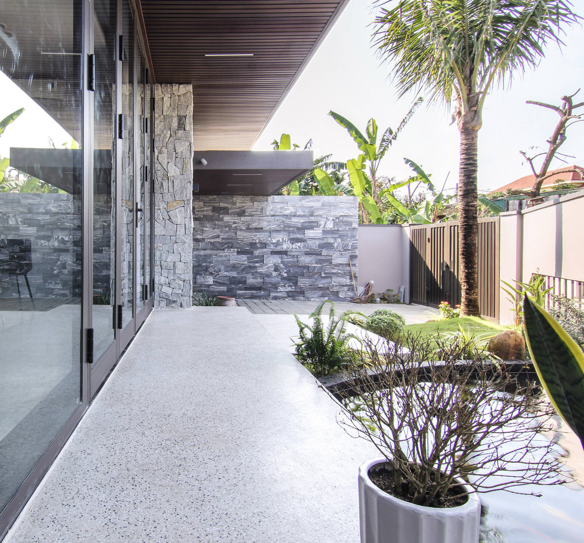 Những phiến đá tự nhiên kết hợp khoảng xanh giúp không gian nhà trở nên gần gũi với thiên nhiên hơn.