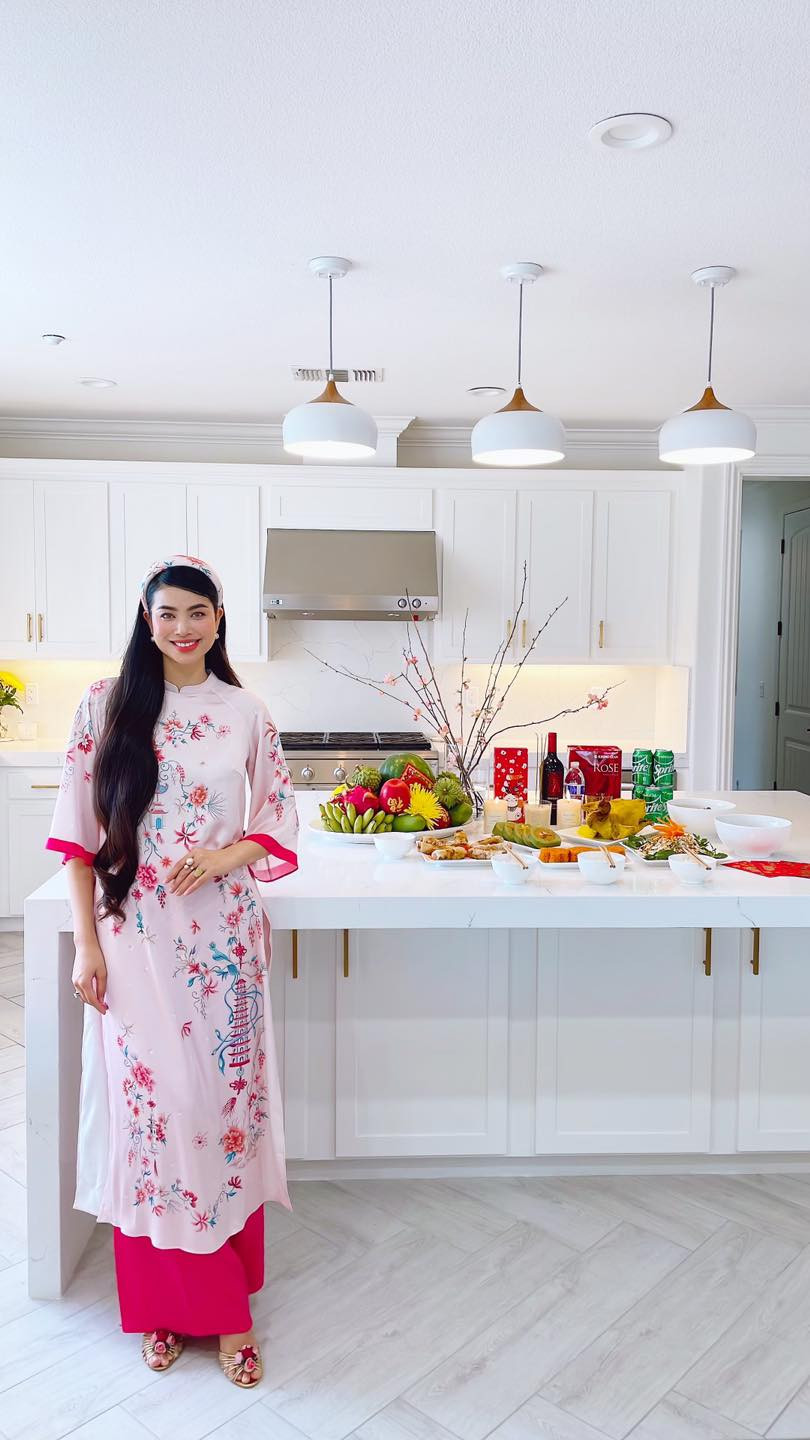 Phòng bếp có gam màu trắng chủ đạo, được tô điểm bằng hoa tươi.