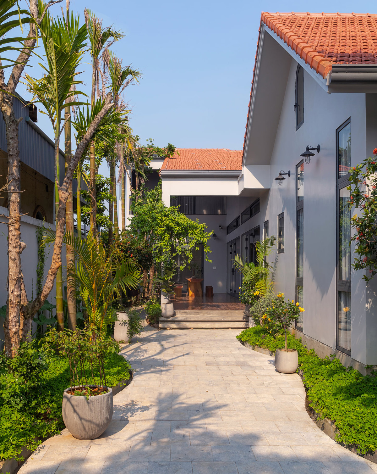 Một điểm ấn tượng nữa trong ngôi nhà là khoảng sân được mô phỏng theo hình ảnh con đường làng uốn lượn, hai bên phủ kín cây xanh.