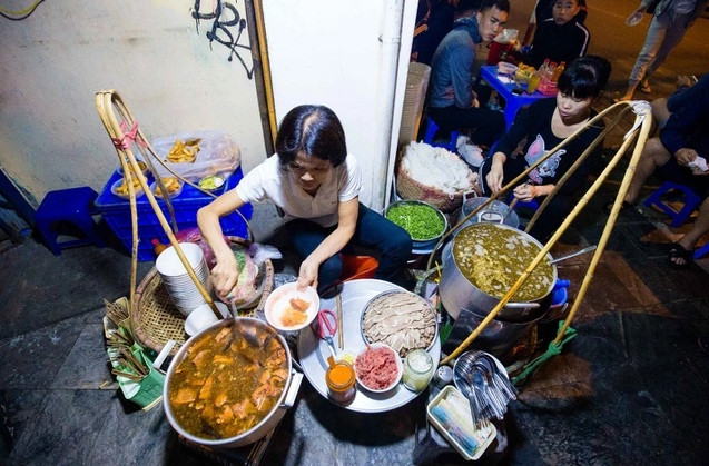 Với những người yêu ẩm thực Hà Nội, phở gánh Hàng Chiếu không còn là cái tên xa lạ. Chủ quán phở đặc biệt này tên là Hoa. Quán bắt đầu mở ở vỉa hè ngã tư Hàng Chiếu – Hàng Đường (Hoàn Kiếm, Hà Nội) năm 1990. Ảnh: Dân trí