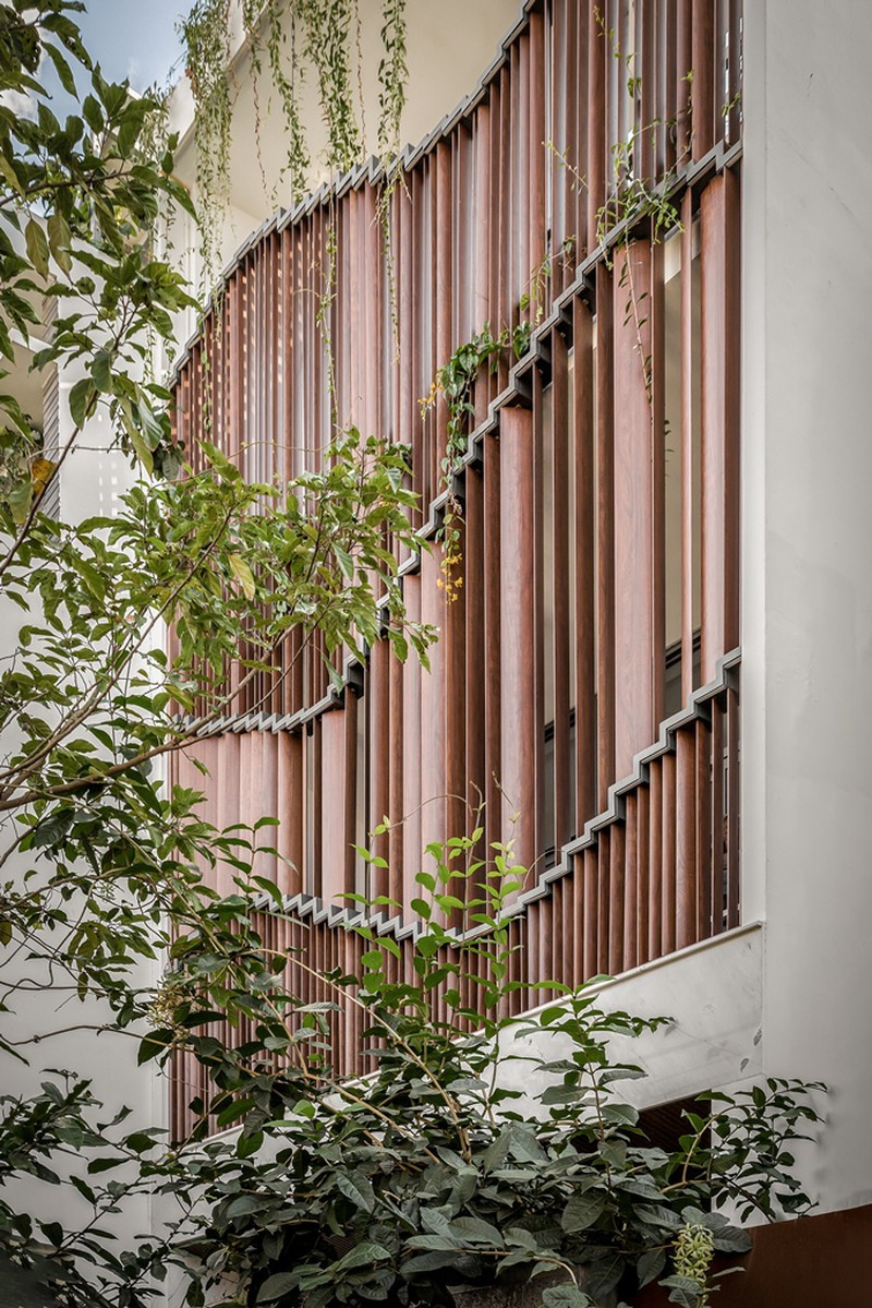 Vì thế, kiến trúc sư thiết kế thêm một lớp vỏ thứ hai phía bên ngoài mặt tiền: hệ lam nhôm vân gỗ lõi thép với khả năng biến đổi hình thức độc đáo.