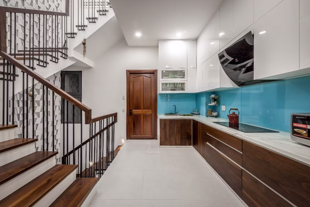 Khu vực sảnh thang bộ được sử dụng cho không gian bếp, tất cả hệ thống tủ kệ được thiết kế âm tường.