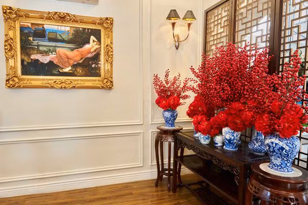 Bên trong một góc biệt thự của Đoàn Di Băng được trang trí rực rỡ với giấy dán tường màu đỏ, bình mai, rổ lì xì...