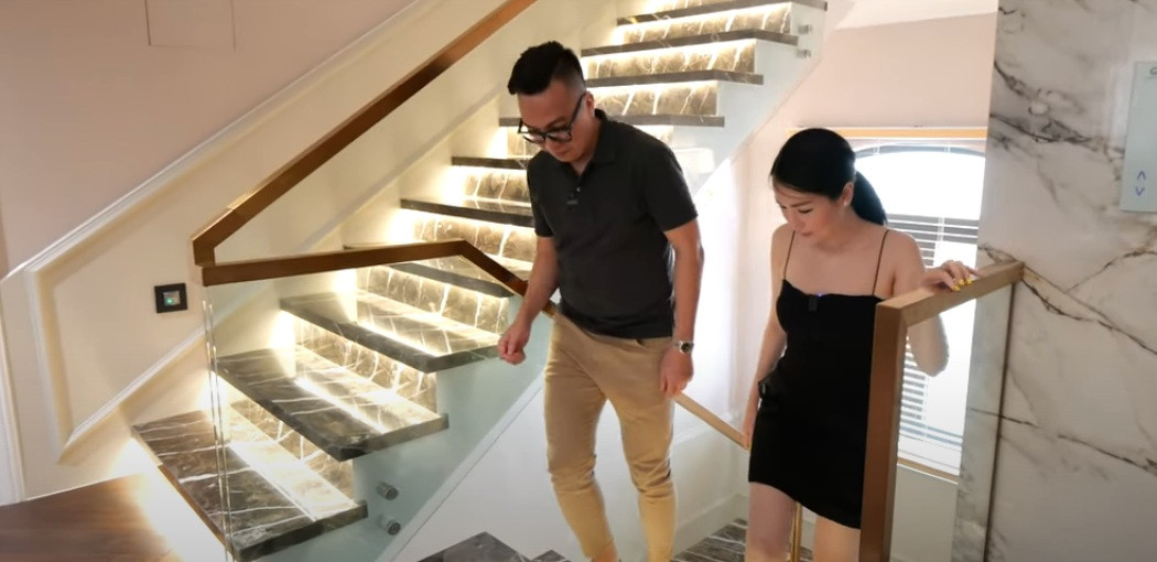 Cầu thang bộ được ốp đá và chạy đèn led ở dưới. Tay vịn cầu thang bằng inox mạ đồng sang trọng.