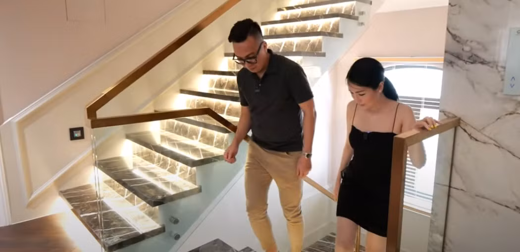 Cầu thang bộ được ốp đá và chạy đèn led ở dưới. Tay vịn cầu thang bằng inox mạ đồng sang trọng.