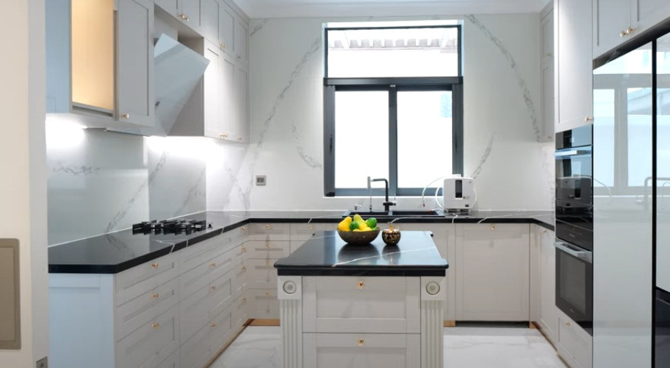 Nhà bếp sử dụng gam màu trắng chủ đạo với hệ thống tủ cả sát trần đến dưới sàn.