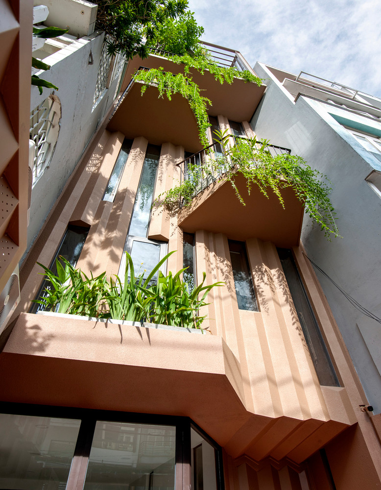 Mặt tiền nhà phố bao gồm các bức tường ngoằn ngoèo giống như đường gờ của vỏ cây, giúp phản xạ âm thanh hiệu quả, giảm tiếng ồn.