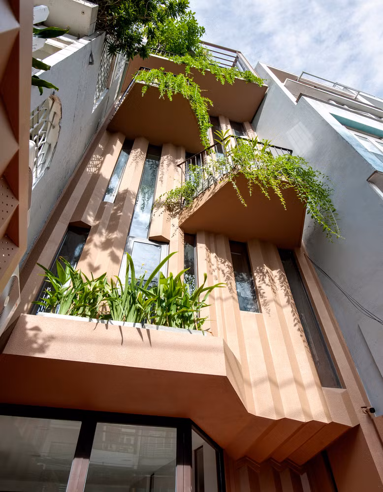 Mặt tiền nhà phố bao gồm các bức tường ngoằn ngoèo giống như đường gờ của vỏ cây, giúp phản xạ âm thanh hiệu quả, giảm tiếng ồn.