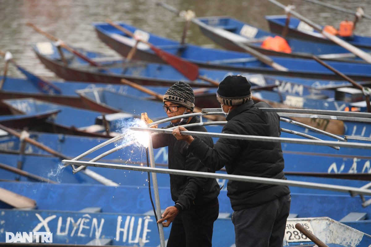 Nhiều nhà thuyền đang tất bật sửa sang, lắp thêm bộ mái che để phục vụ chở khách trong thời tiết mưa phùn.