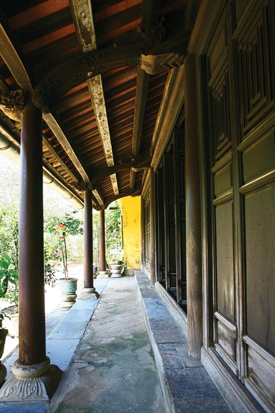 Hiên nhà với những hàng cột gỗ kê trên chân tảng hình vuông. Ảnh: Tcnhadep