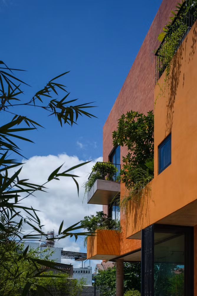 Nhóm kiến trúc sư lựa chọn hình thức đơn giản với lớp sơn màu cam ngoại thất, tạo điểm nhấn nổi bật trên nền cỏ xanh mướt cũng như cây cối bao quanh.