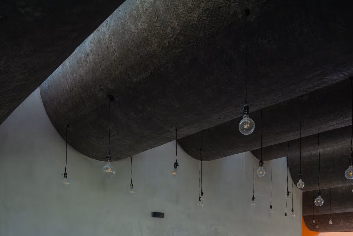 Phần mái cong bằng bê tông khiến bên trong như một sự phá cách tương phản với nét vuông vắn, cứng cáp phía ngoài căn nhà.