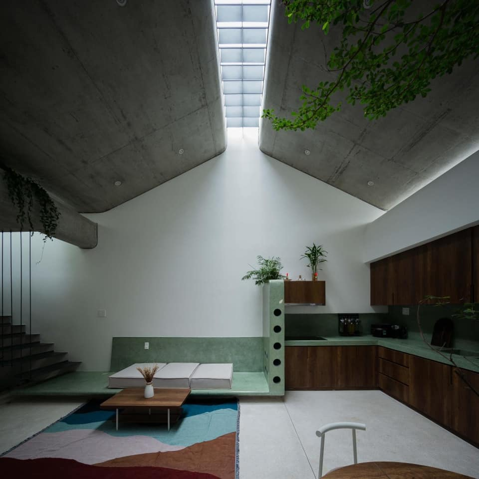 Phòng khách thiết kế gọn gàng với tông màu gỗ, trắng, xanh tươi sáng.