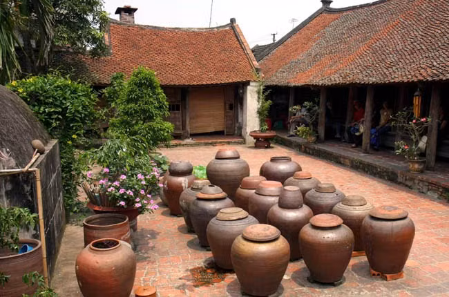 Nhà có khoảng sân rộng xếp đều tăm tắp các vại tương của cha ông để lại bao đời. Ảnh: Cand