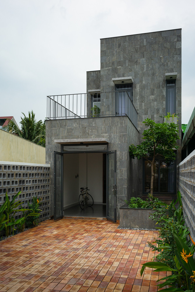 Ở bên ngoài, kiến trúc sư sử dụng đá tự nhiên, khối bê tông và gạch thô, mục đích để tạo ra cảm giác chuyển đổi không gian giữa bên trong và bên ngoài. Nguồn ảnh: Quang Dam