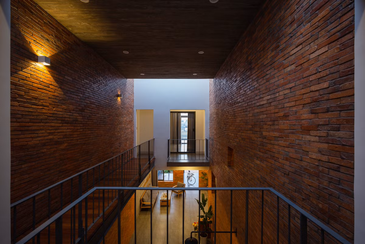 Để kết nối hai không gian tầng trên, kiến trúc sư thiết kế một cây cầu thép thay vì một hành lang bê tông. Đây cũng là điểm nhấn của ngôi nhà.