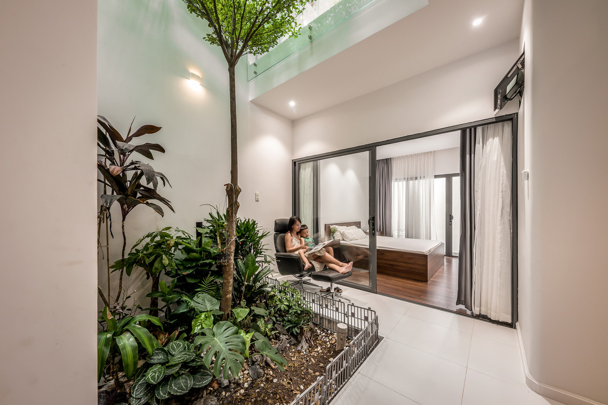 Phòng ngủ cho ông bà được bố trí thêm giữa 2 sân vườn ở tầng trệt, 2 phòng ngủ cho con 5 tuổi và bố mẹ ở tầng 2.