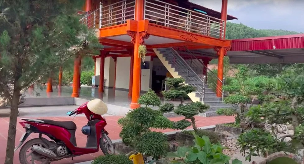 Phần sân của căn nhà có tổng diện tích 310m2, được lát gạch đỏ và trang trí nhiều bonsai và nhiều loại cây trồng lâu năm. Ảnh chụp màn hình