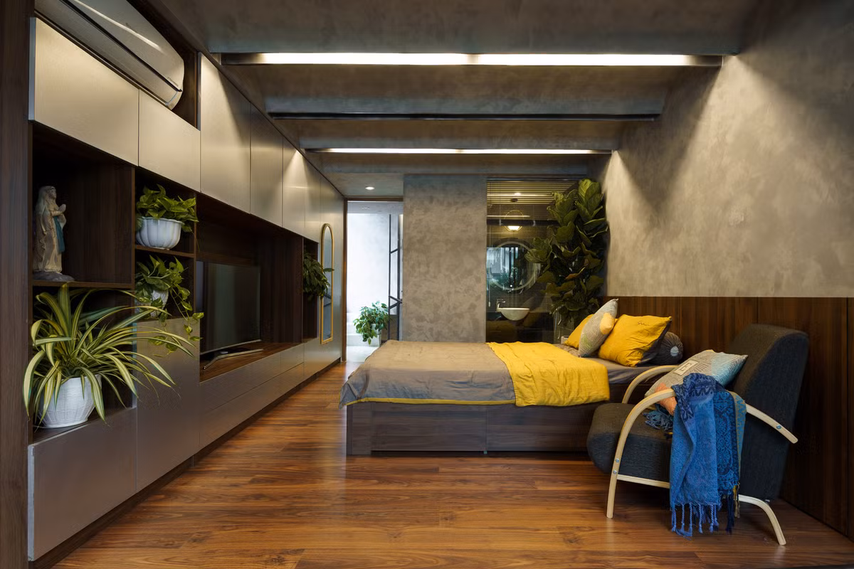 Phòng ngủ rộng được trang trí bởi nhiều chậu cây xanh.