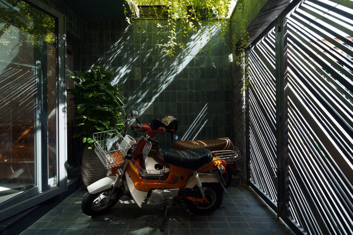 Sân trước được che phủ bởi lớp dây leo rủ xuống cùng thiết kế song cửa kín đáo vừa đảm bảo sự riêng tư vừa chắn nắng từ bên ngoài.